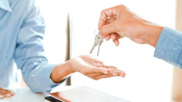 Midsection Of Real Estate Agent Giving House Key To Customer While Picture Id1194686907